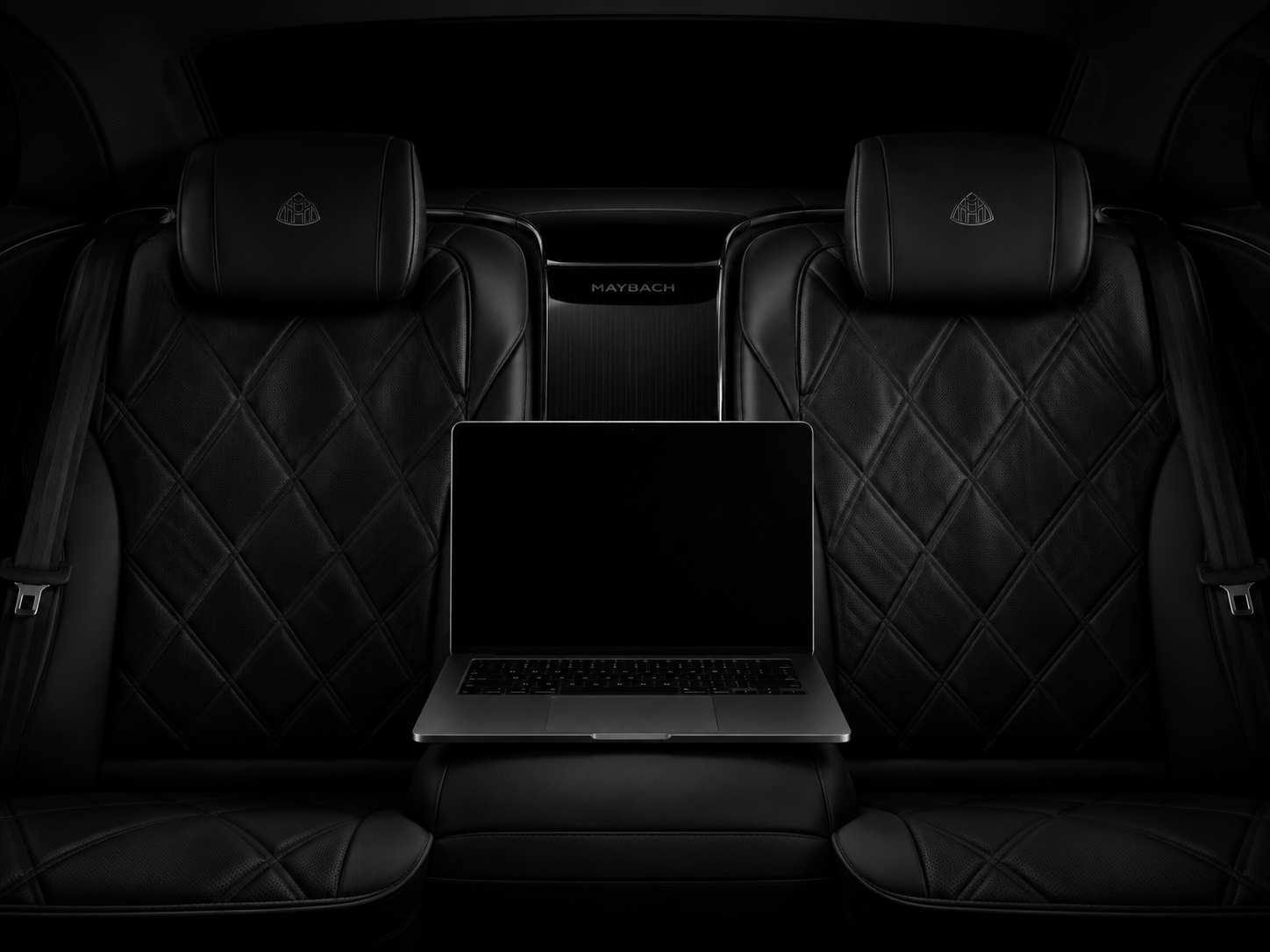 Black executive rear seat with a laptop centered on the console for Envelope inbox work